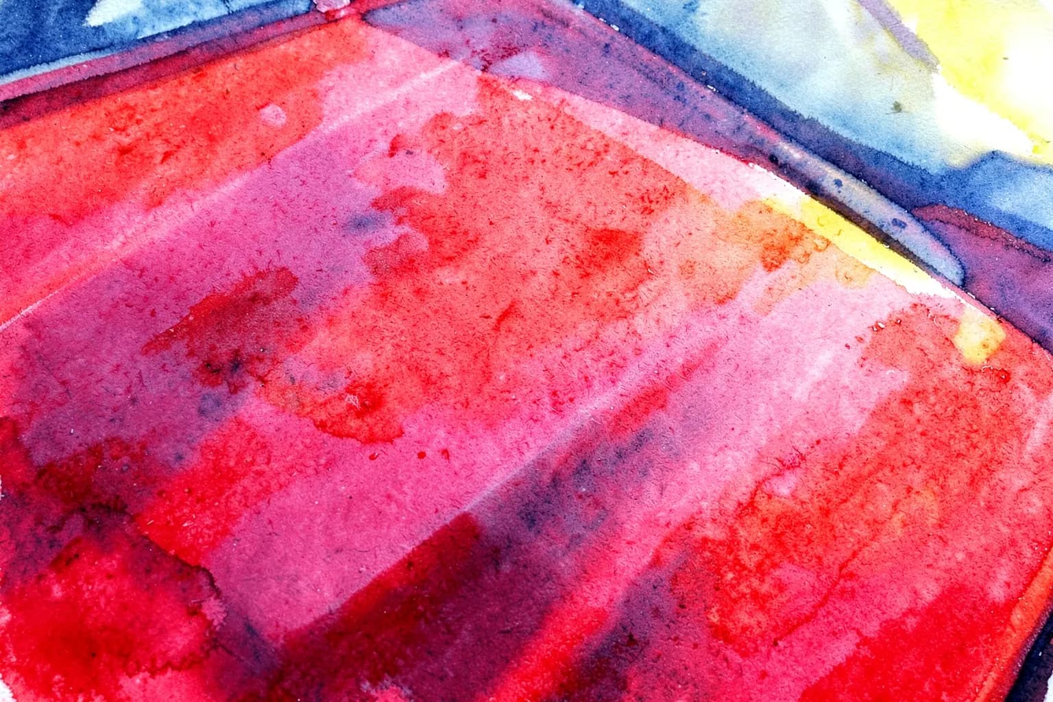 Um carro vermelho brilhante sendo polido com uma máquina politriz, close-up em um detalhe da pintura.